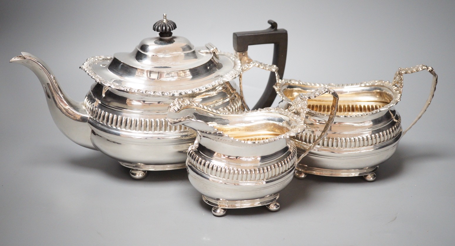 A George V silver three piece tea set, with fluted band, Nathan & Hayes, Chester, 1913/4